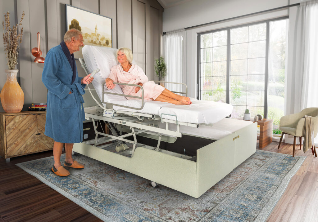 Couple with their height adjustable electric bed using the hand control
